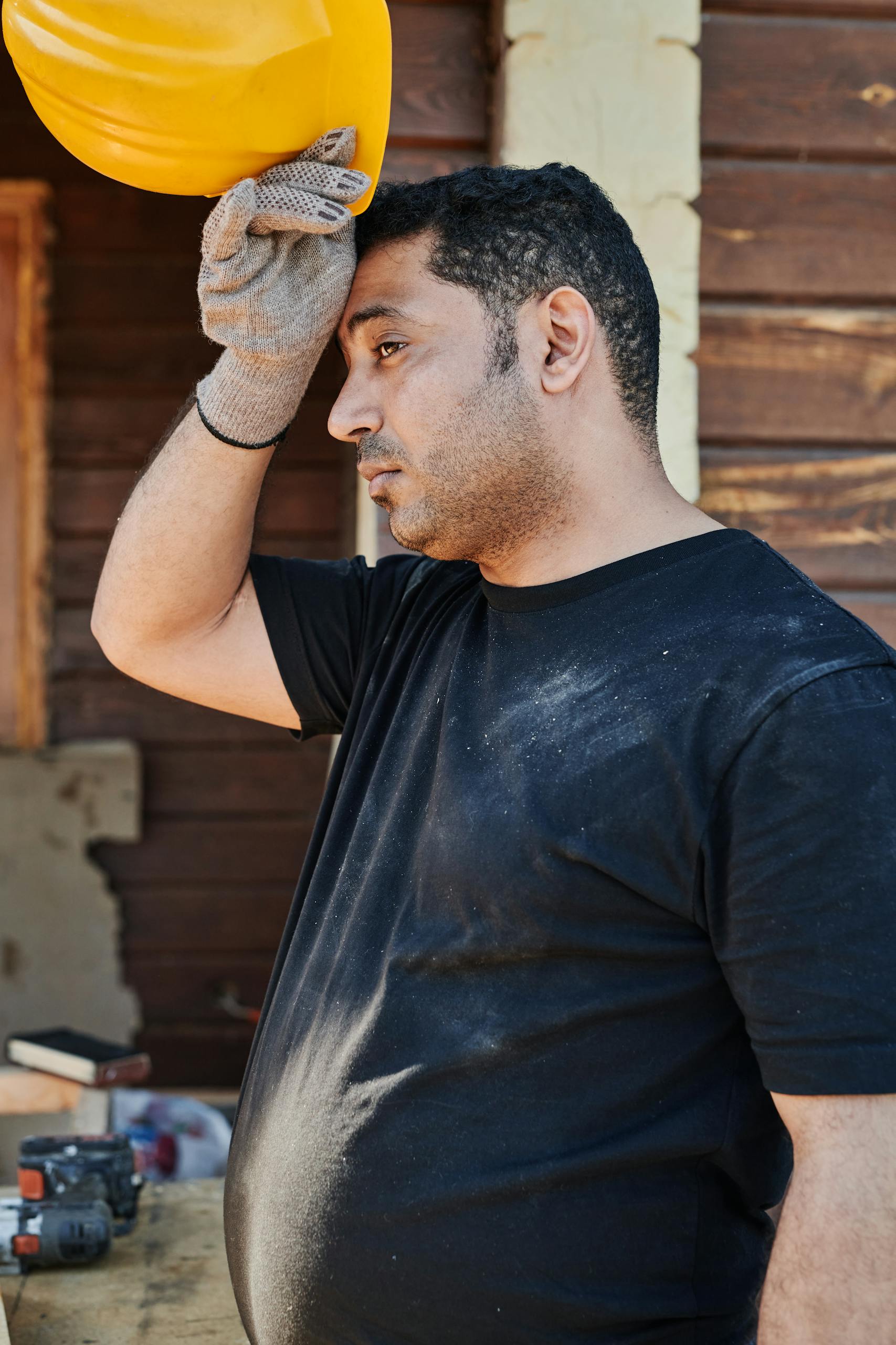 A man in Black Shirt Holding a Safety Helmet